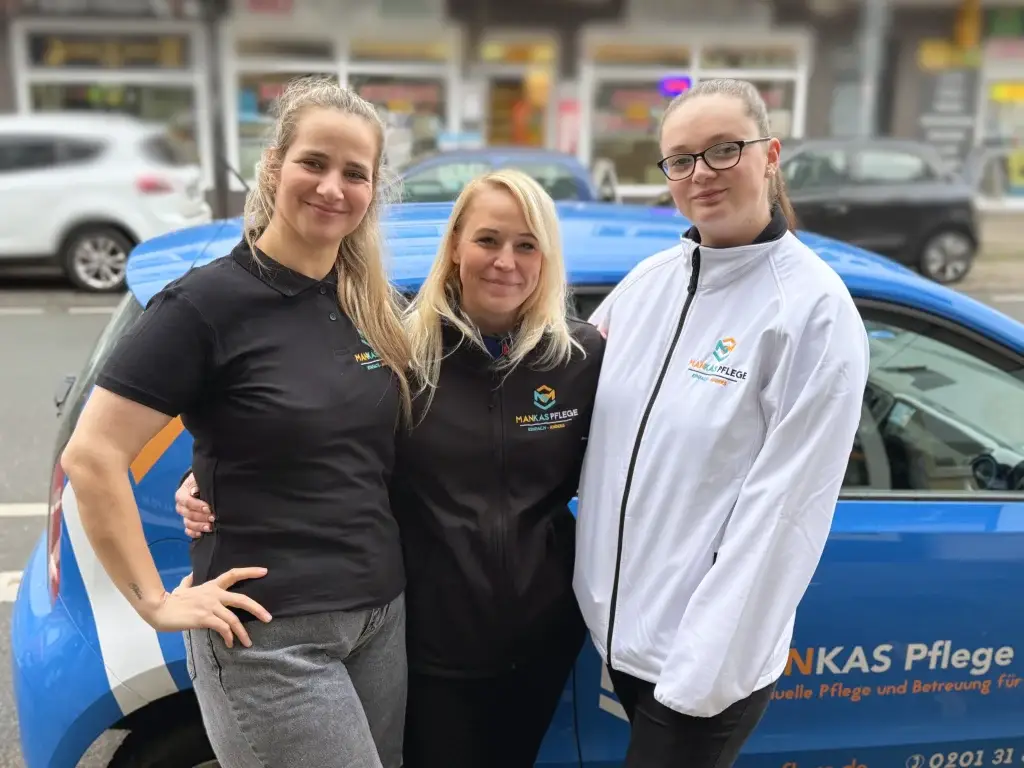 Pflegekräfte von Mankas Pflege vor einem Firmenfahrzeug – jetzt Pflegejob in Essen sichern!